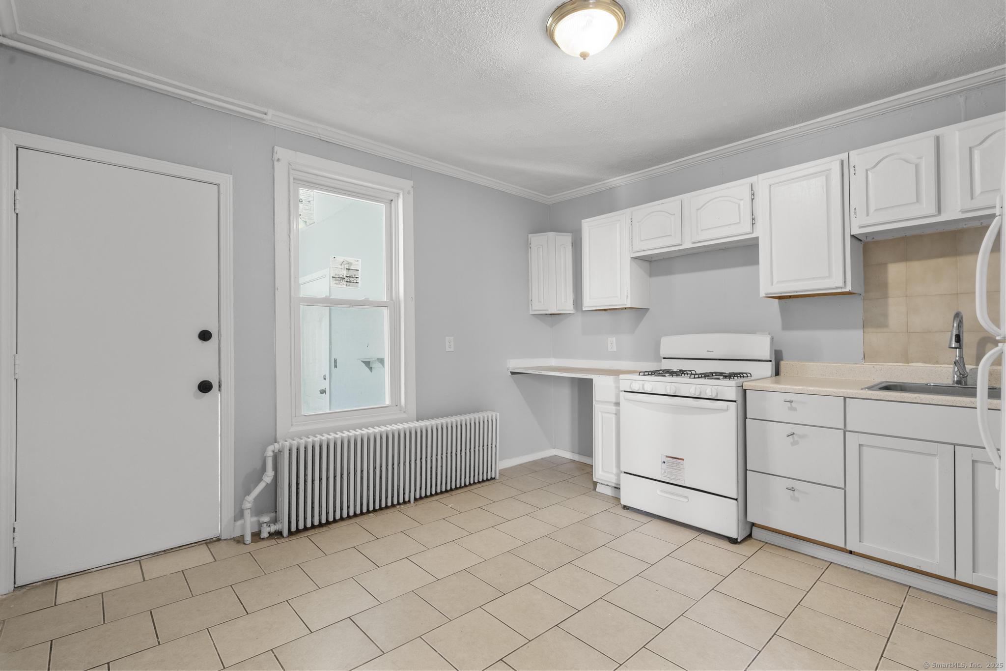 19 Whitmore Street Hartford, CT 06114 - Photo 4 of 27 a kitchen with white cabinets a sink and dishwasher