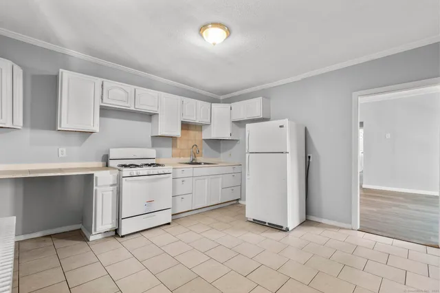 a kitchen with white cabinets and white appliances