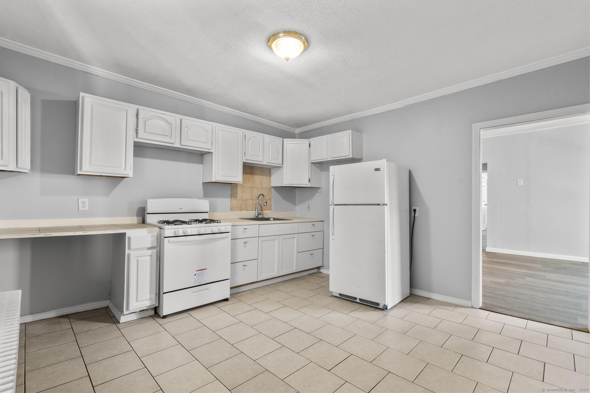 19 Whitmore Street Hartford, CT 06114 - Photo 5 of 27 a kitchen with white cabinets and white appliances