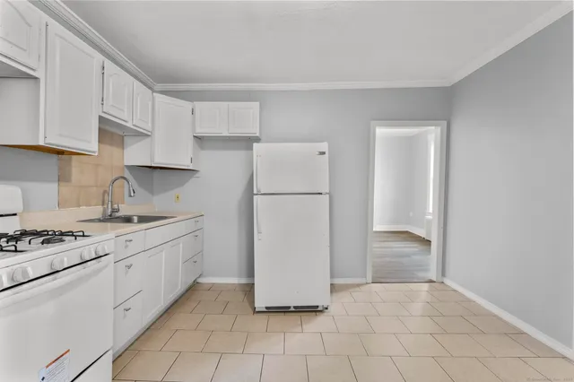 a kitchen with a refrigerator a stove top oven and cabinets
