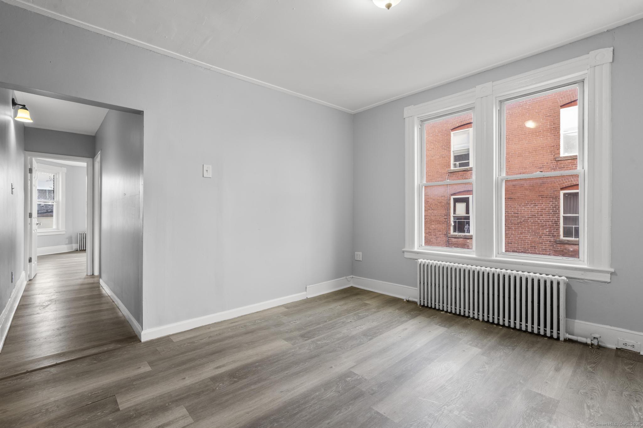 19 Whitmore Street Hartford, CT 06114 - Photo 8 of 27 a view of an empty room with wooden floor and a window