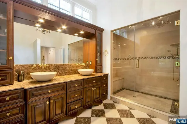 a bathroom with a granite countertop sink mirror and shower