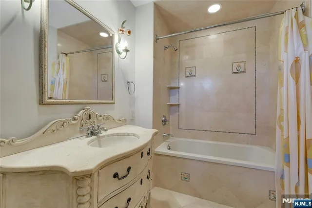 a bathroom with a sink double vanity mirror and a bathtub