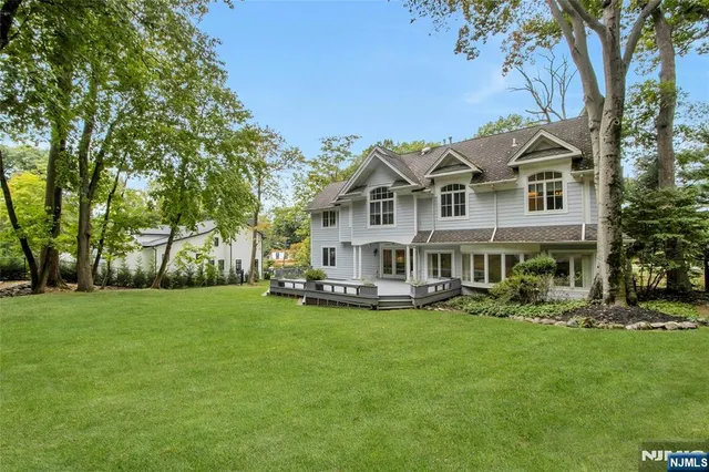 a front view of a house with a garden and trees