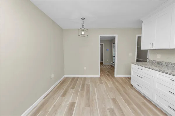 wooden floor in an empty room with a kitchen
