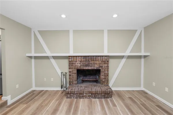 a living room with a fireplace and a ceiling fan