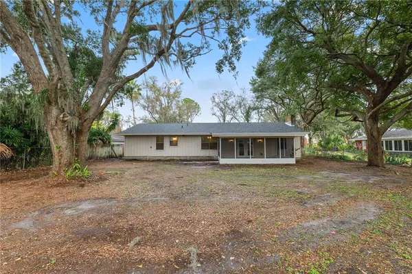a view of a house next to a big yard with large trees