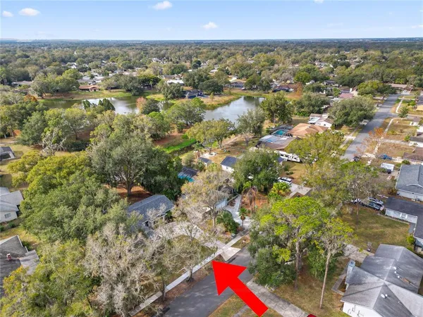 an aerial view of residential houses with outdoor space and trees