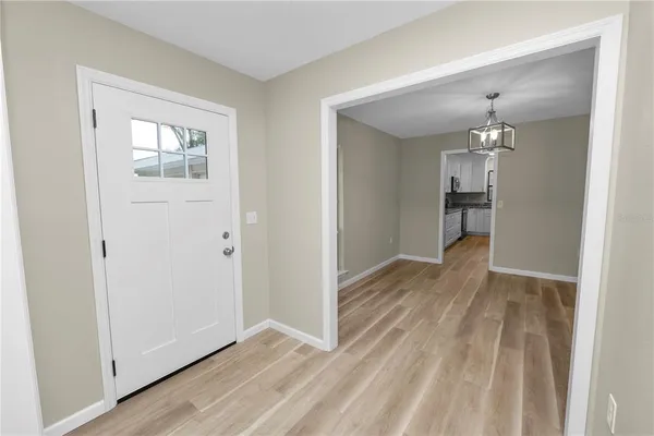 a view of a room with wooden floor a ceiling fan and a window