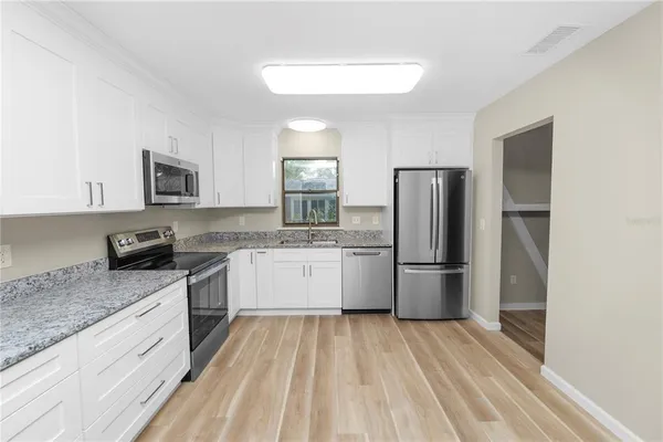 a kitchen with a refrigerator a stove top oven a sink and dishwasher