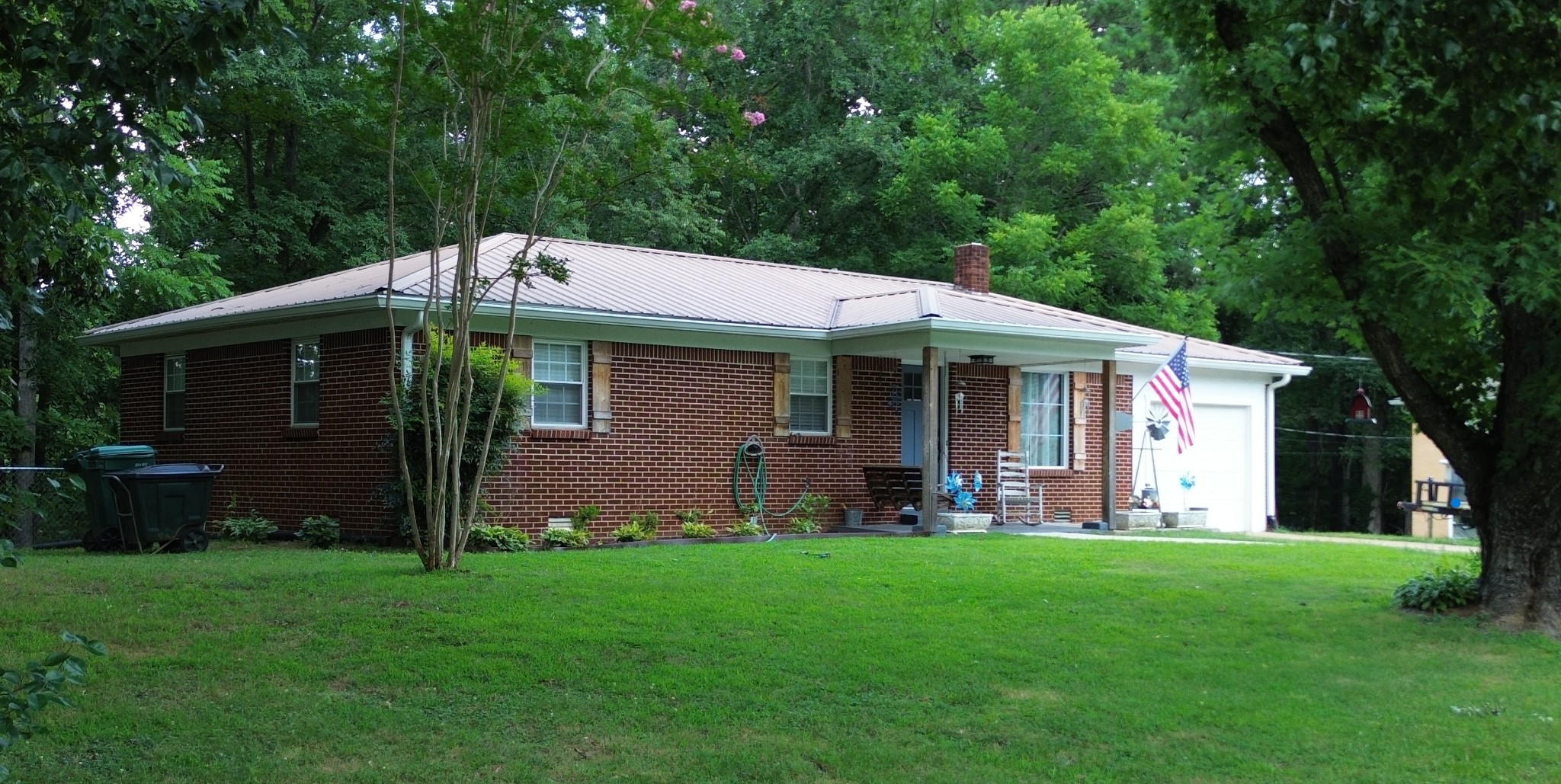 a front view of a house with a garden and yard