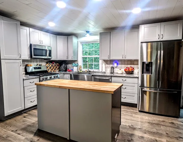 a kitchen with stainless steel appliances a refrigerator sink and microwave