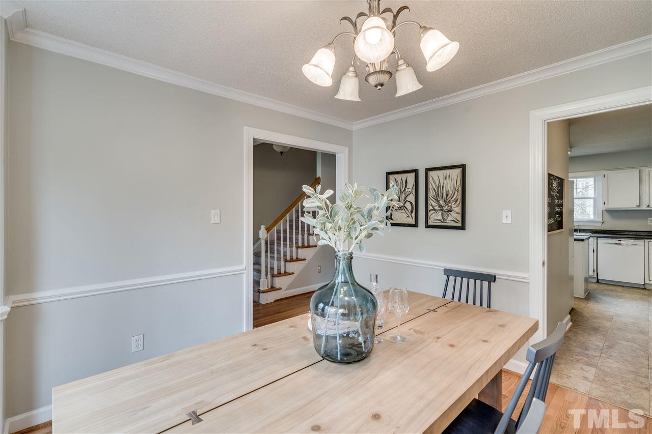1 Swallows Ridge Court Durham, NC 27713 - Photo 12 of 26 a dining room with wooden floor a chandelier a wooden table and chairs