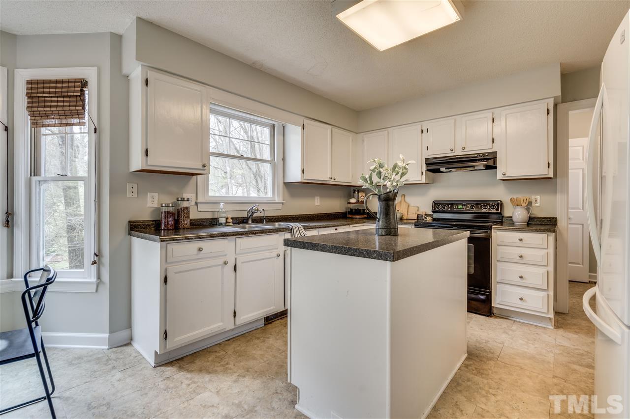 1 Swallows Ridge Court Durham, NC 27713 - Photo 14 of 26 a kitchen with granite countertop white cabinets and white appliances