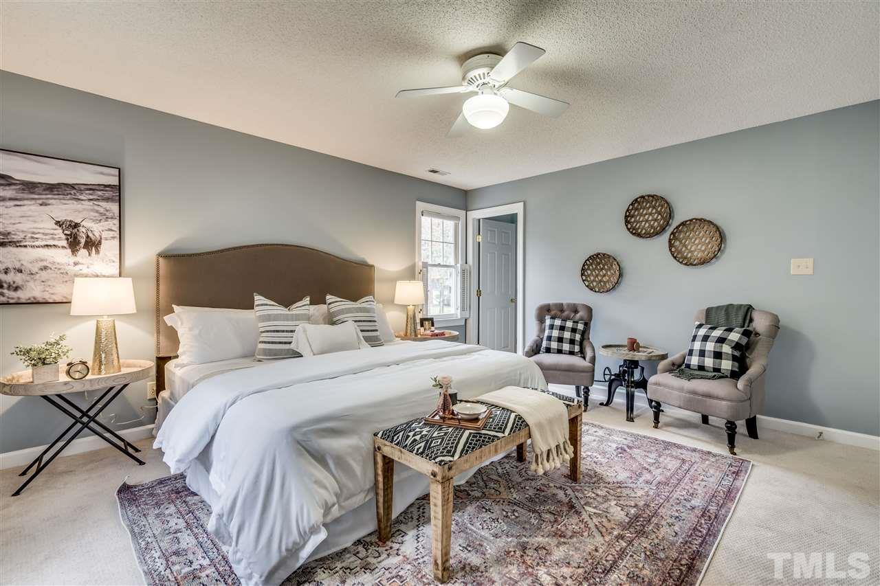 1 Swallows Ridge Court Durham, NC 27713 - Photo 19 of 26 a bedroom with a bed a chair and a chandelier