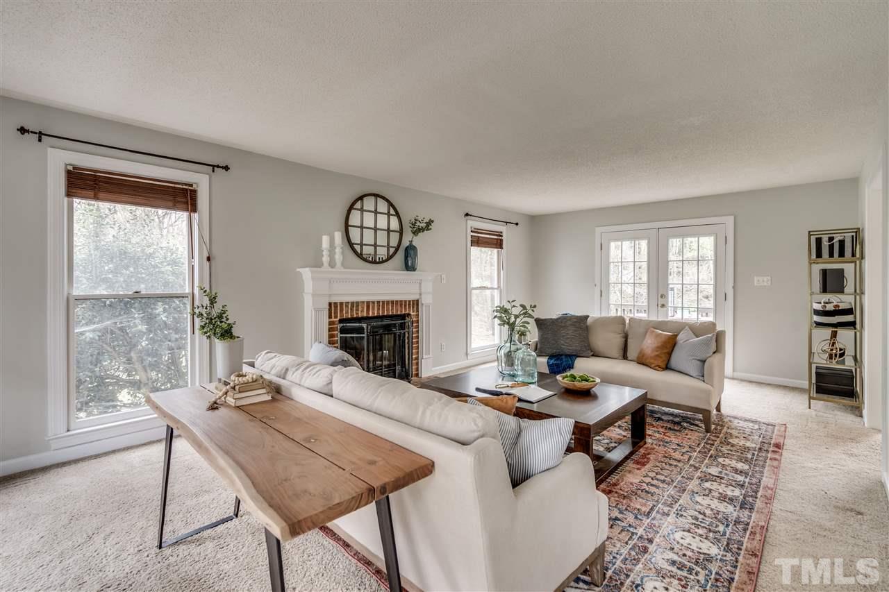 1 Swallows Ridge Court Durham, NC 27713 - Photo 5 of 26 a living room with furniture a fireplace and a table
