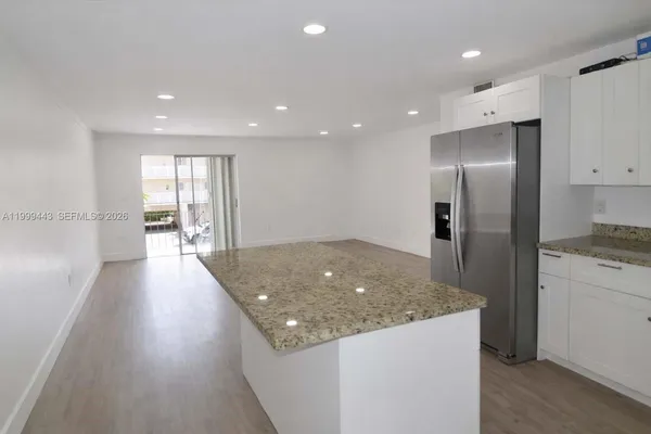 a kitchen with stainless steel appliances granite countertop a refrigerator a sink and a stove top oven