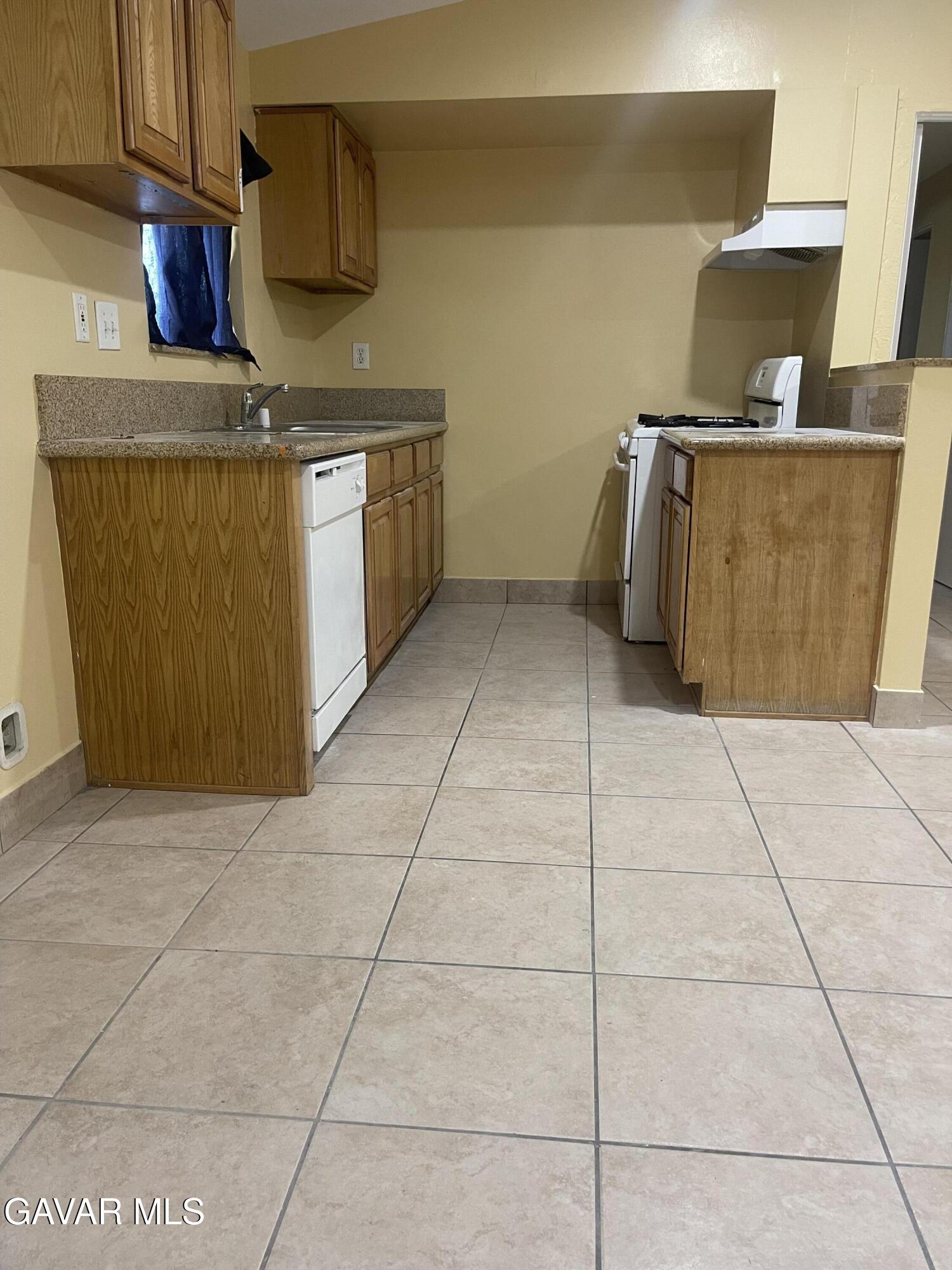 2004 Oldfield Street, Unit B Lancaster, CA 93536 - Photo 6 of 12 a kitchen with a stove top oven cabinets and a counter top space