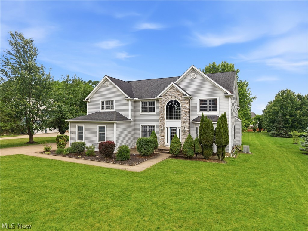 11678 Dunham Road Northfield, OH 44067 - Photo 2 of 38 Expansive light gray two-story residence featuring stone facade accents, multiple gables, and a prominent arched window above the entry