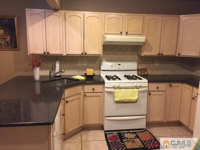 23 Richmond Road Edison, NJ 08817 - Photo 3 of 13 a kitchen with granite countertop a sink a stove and cabinets