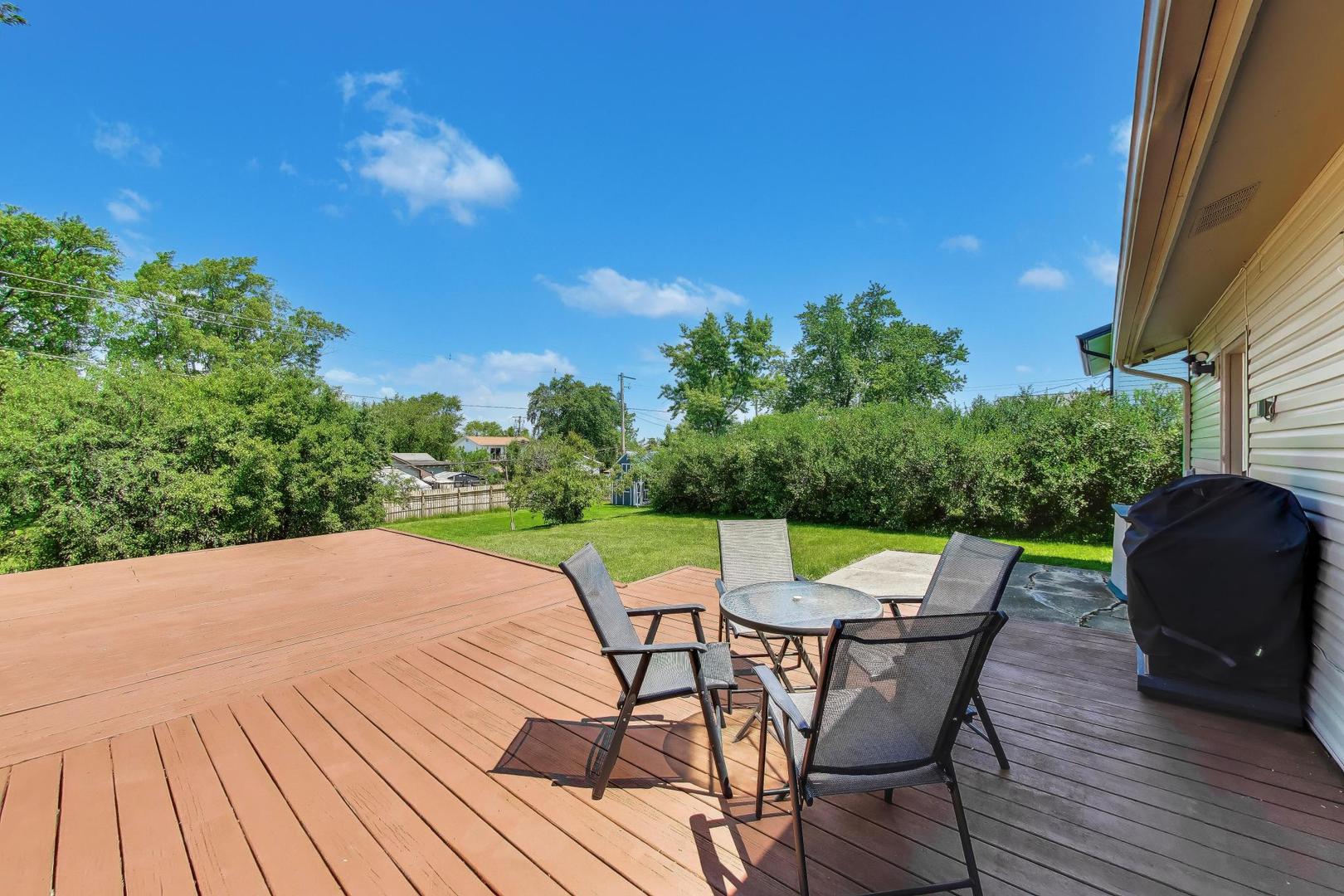 420 Bode Road Hoffman Estates, IL 60169 - Photo 16 of 20 a view of a roof deck with table and chairs couches with wooden floor and fence
