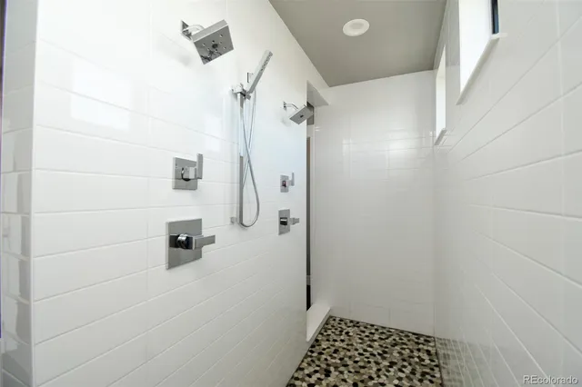 a bathroom with a double vanity sink a mirror and a shower