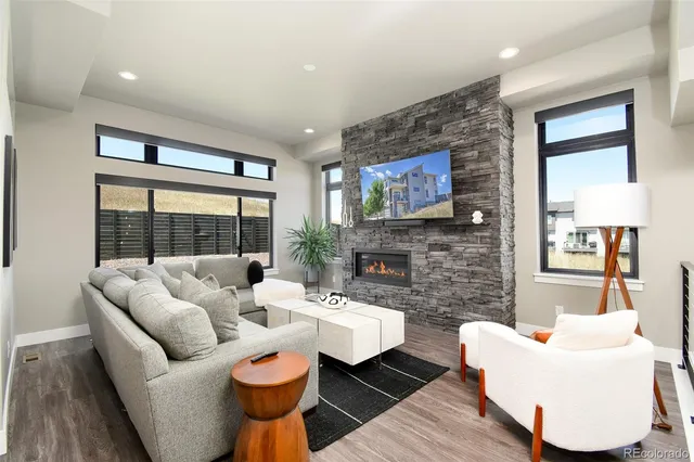 a living room with fireplace furniture and a large window