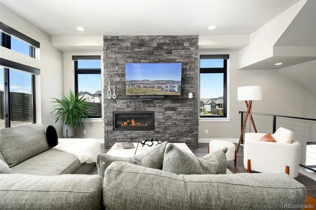 a living room with furniture a fireplace and a flat screen tv