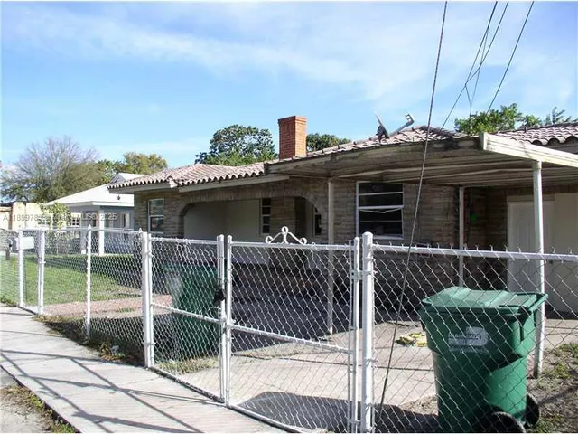 a view of a house with a balcony and next to a yard