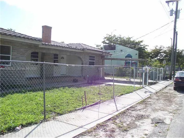 a view of a house with a yard and potted plants