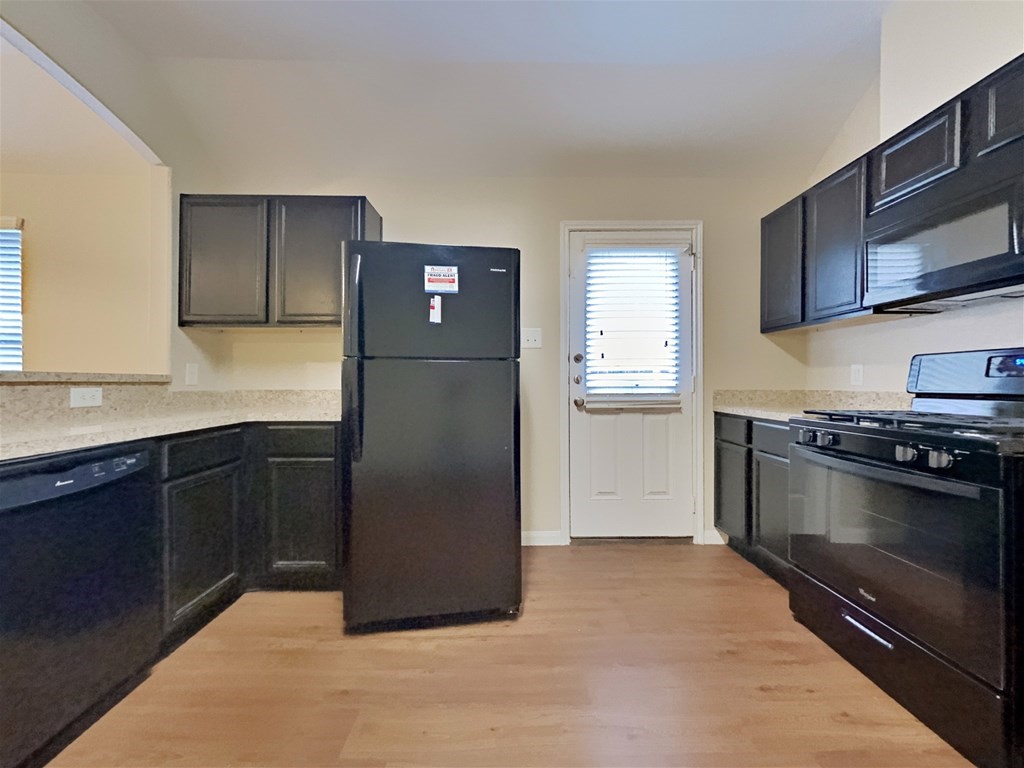21535 Micheala Way Humble, TX 77338 - Photo 2 of 17 a kitchen with stainless steel appliances granite countertop a refrigerator a stove a sink and a microwave