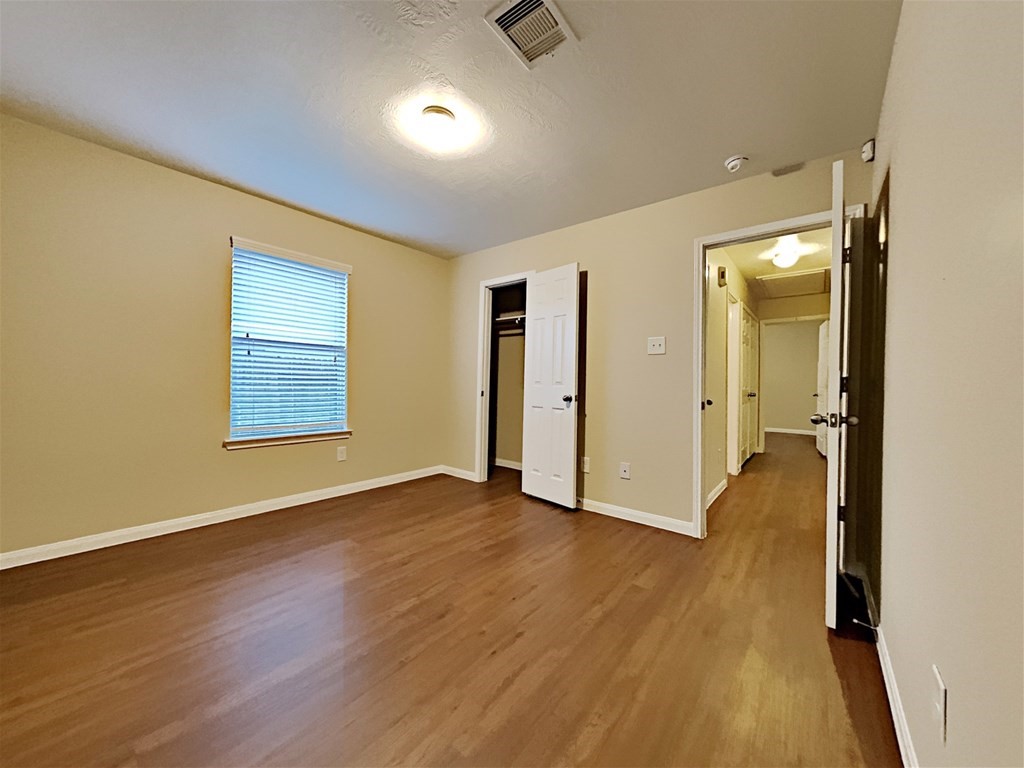 21535 Micheala Way Humble, TX 77338 - Photo 10 of 17 an empty room with wooden floor and a window