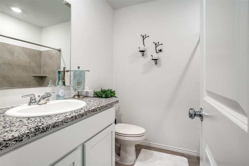 142 Sesame Lane Princeton, TX 75407 - Photo 10 of 15 a bathroom with a granite countertop sink mirror vanity and toilet