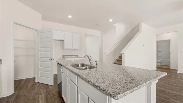 a kitchen with stainless steel appliances granite countertop a sink stove and cabinets