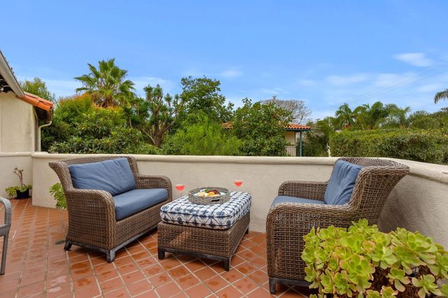 a balcony with furniture and a potted plant