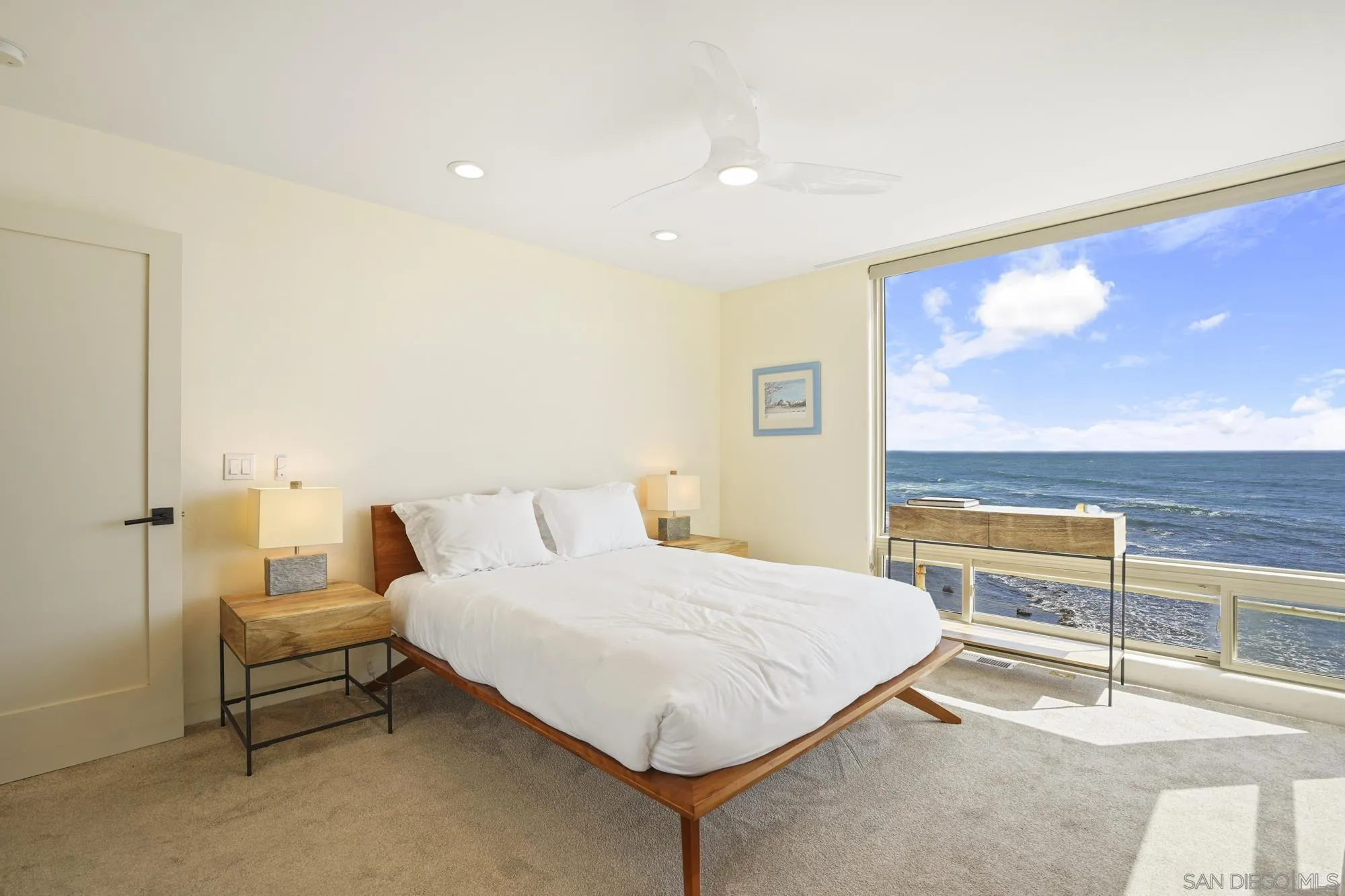 5650 Dolphin Place La Jolla, CA 92037 - Photo 32 of 54 a bedroom with a bed and glass wall view