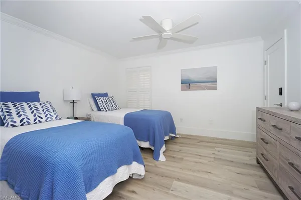 a bedroom with two beds and a chair