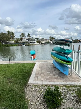 a view of a lake with a yard and large trees