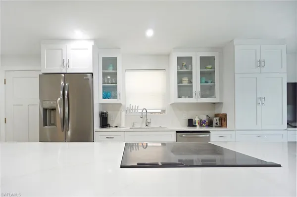 a kitchen with stainless steel appliances granite countertop a refrigerator a stove and a sink