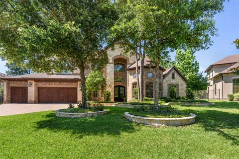 front view of a house with a yard and palm trees