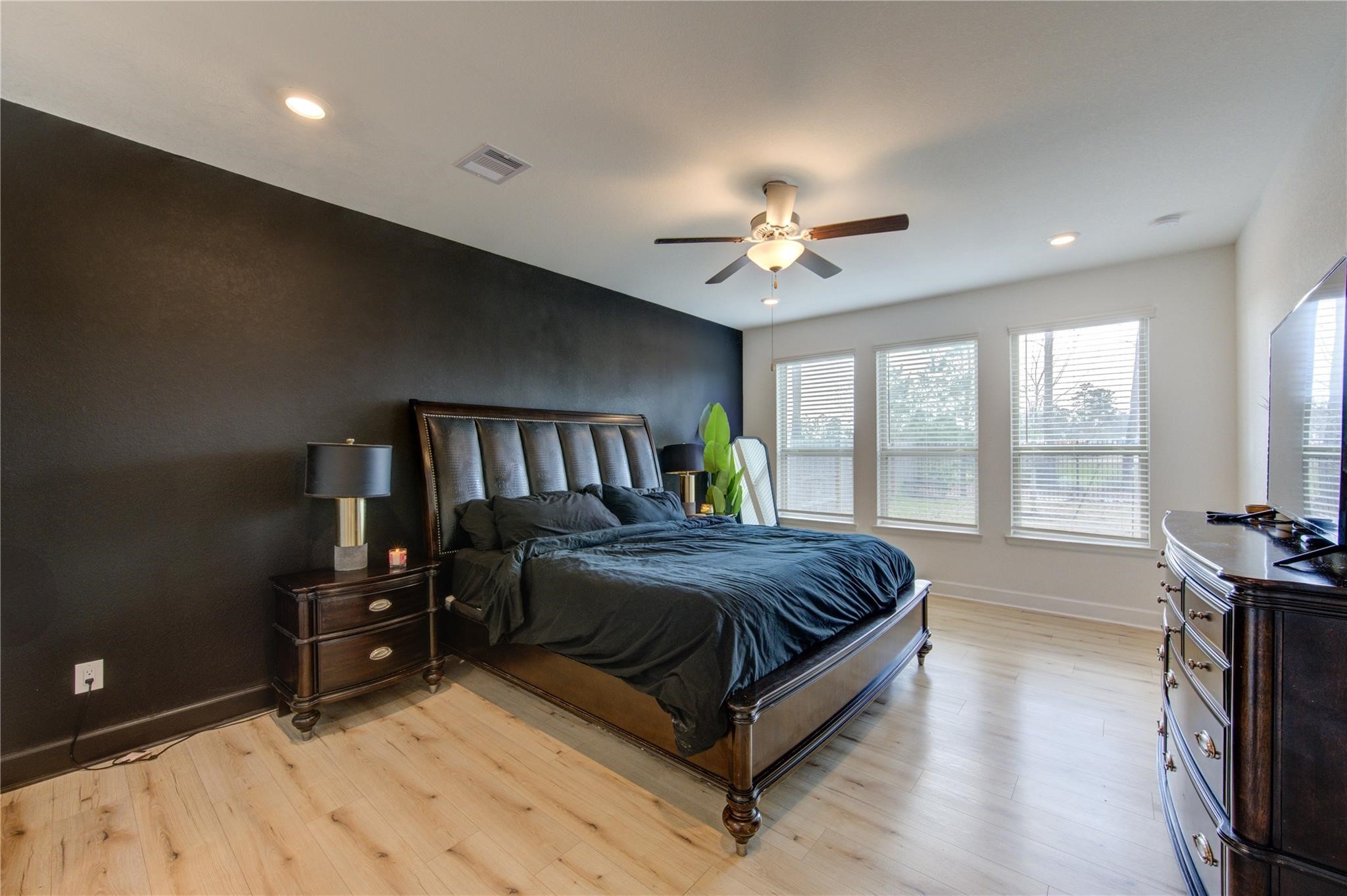 17530 Sunset Skies Road Conroe, TX 77302 - Photo 22 of 47 a spacious bedroom with a bed a dresser and a large window