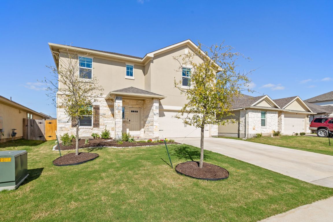 a front view of a house with a yard and garage