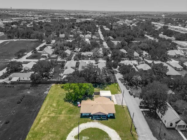 an aerial view of residential houses with outdoor space and swimming pool
