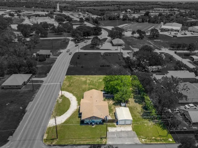 an aerial view of a house with a garden and lake view