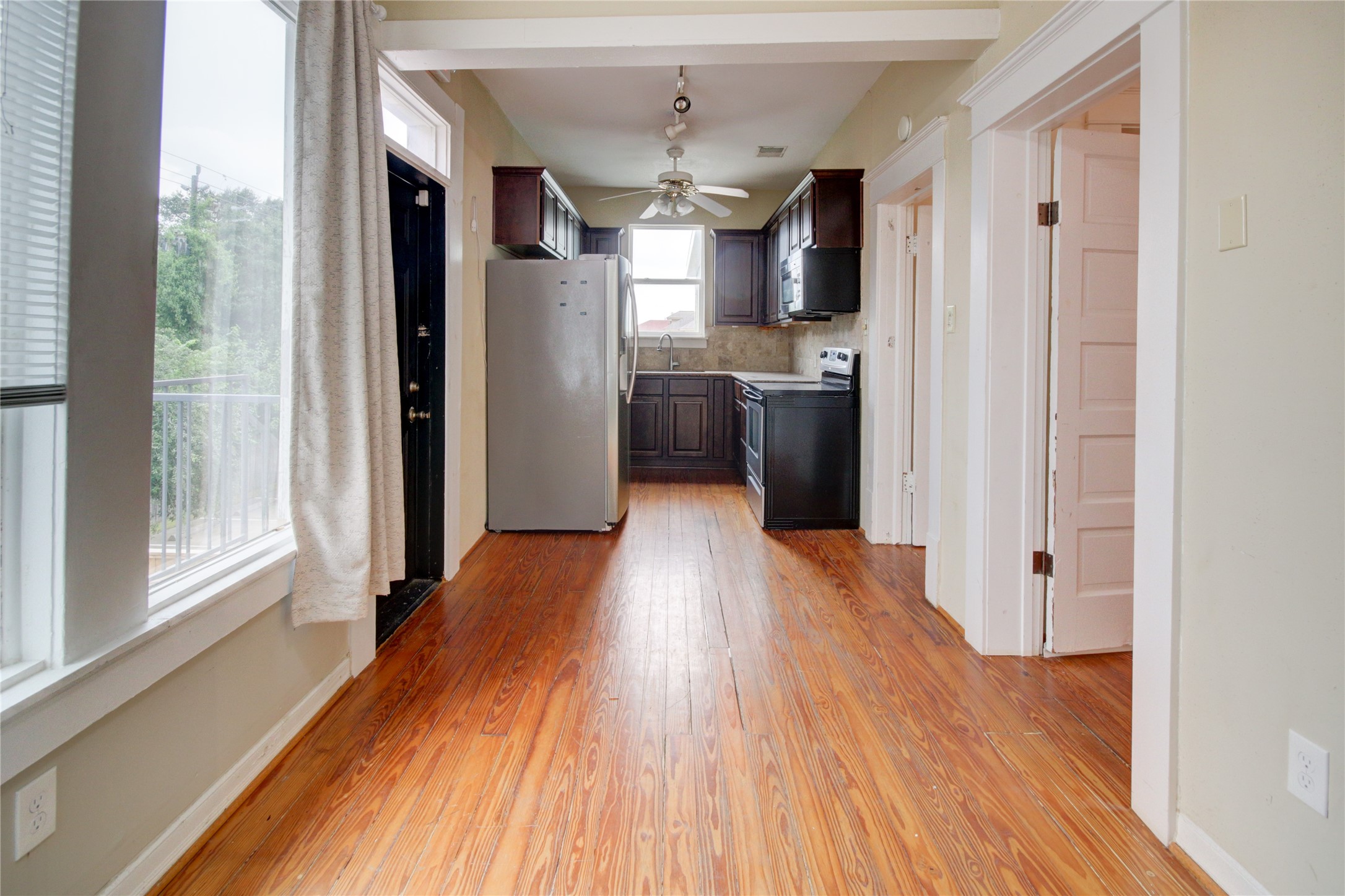 239 Westheimer Road Houston, TX 77006 - Photo 28 of 50 a view of a kitchen with stainless steel appliances wooden floor and a window