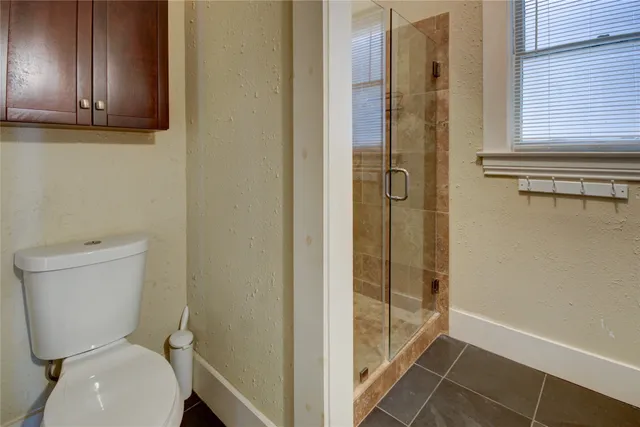 a bathroom with a toilet and a shower