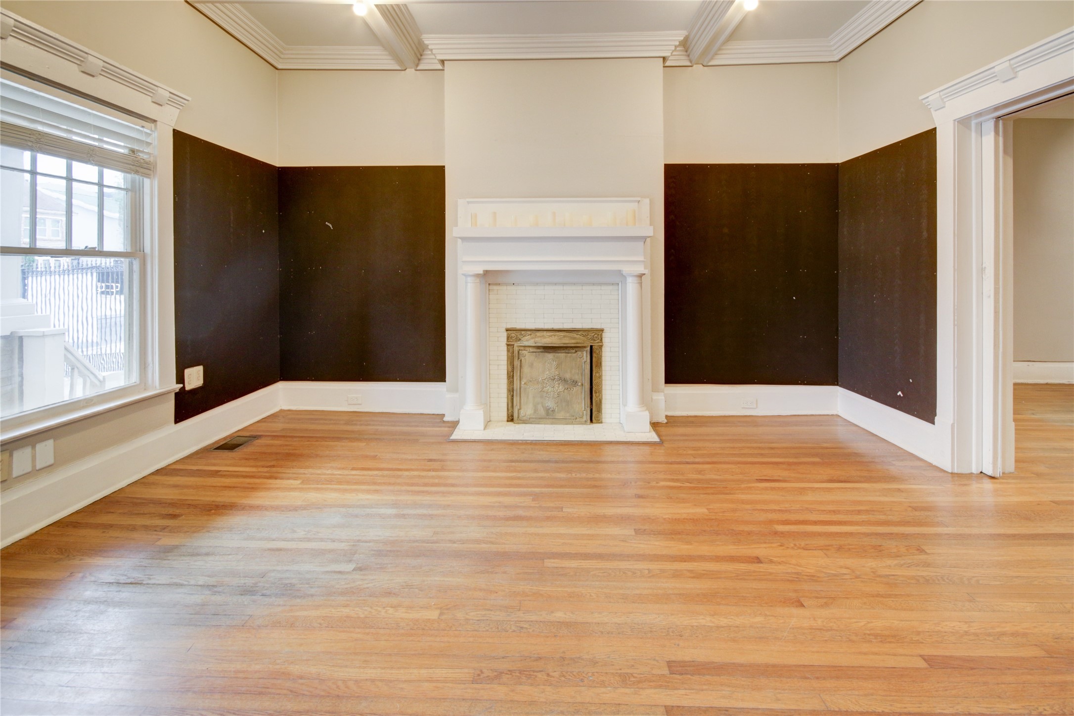 239 Westheimer Road Houston, TX 77006 - Photo 9 of 50 a view of an empty room with wooden floor and a fireplace