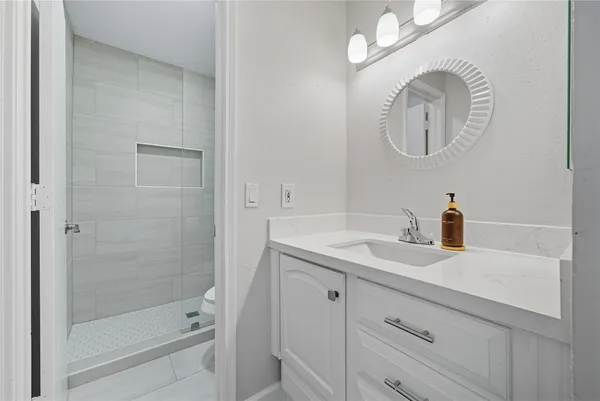 a bathroom with a sink a toilet and a mirror