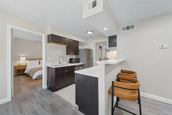 a large white kitchen with sink and cabinets