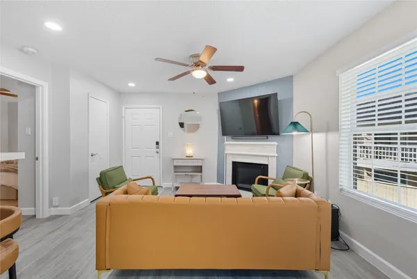 a living room with furniture a fireplace and a flat screen tv